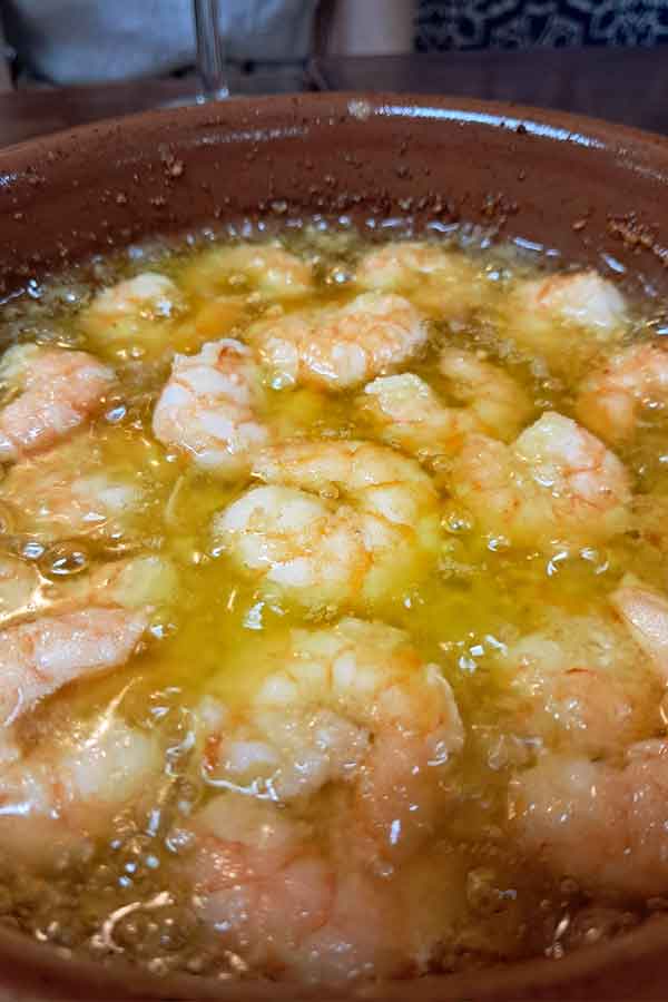 Gambas Al Ajillo Gambas Al Ajillo which is a bubbling hot dish of shrimp covered in extra virgin olive oil, garlic and chilli.