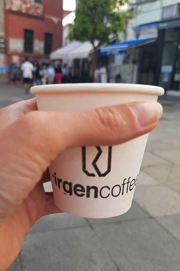 Virgen Coffeee cup. A self printed cup with the logo on a paper cup and my hand holding it.