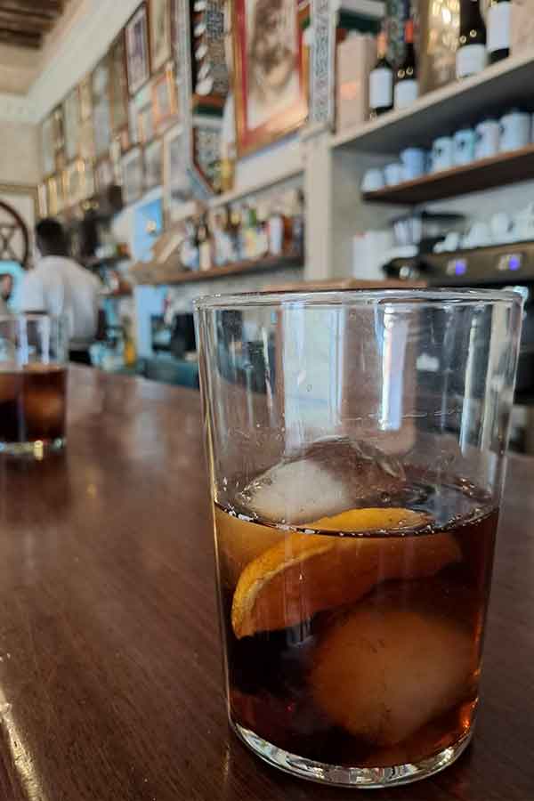 Vermouth at Bar Santa Ana A glass of Vermouth with two ice cubs and a slive of orange in it.