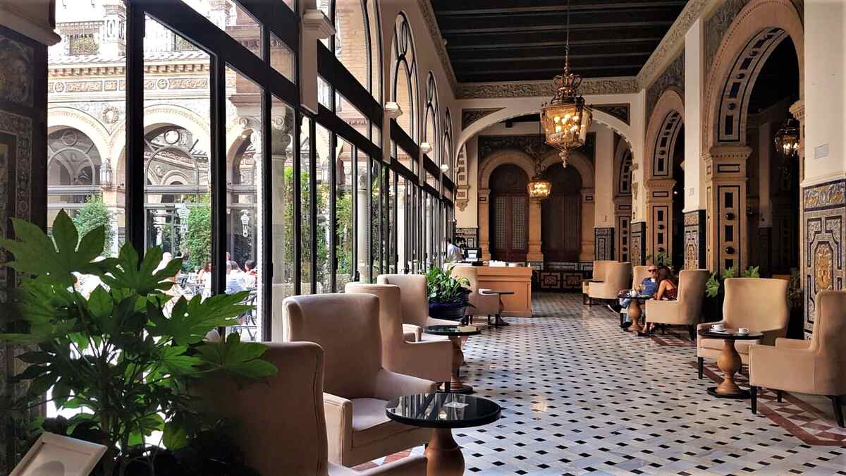 Where to stay in Seville, Spain, featuring the elegant tiled interior of Hotel Alfonso XIII.