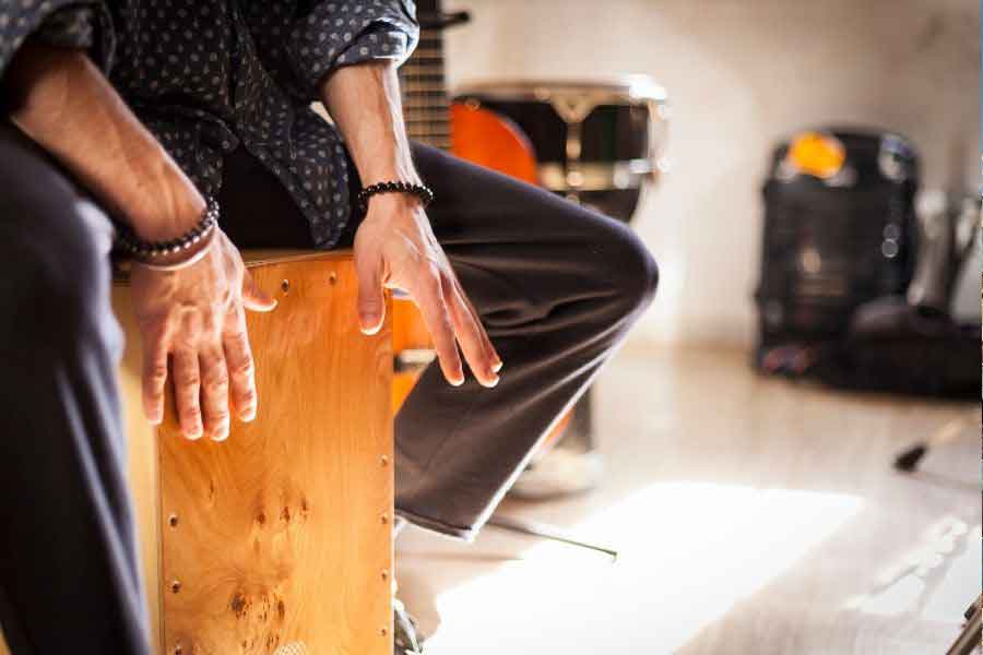 Cajón Flamenco Musician playing a wooden cajón drum, a key rhythm instrument used in flamenco performances that evolved alongside Spain’s folk music traditions.