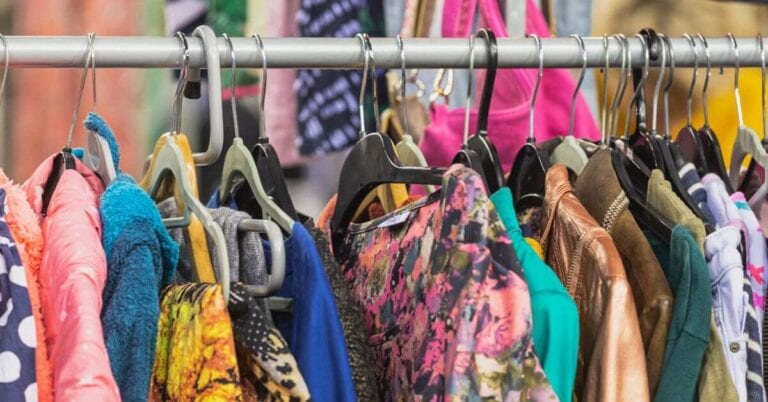 Clothing rack inside one of the best vintage shops in Seville, filled with colorful retro jackets, dresses, and secondhand finds.