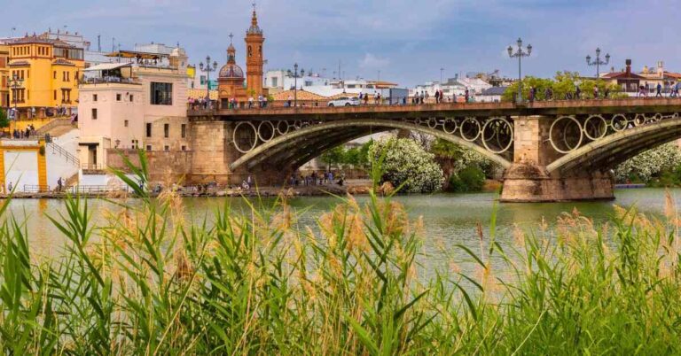 Seville’s Triana Bridge over the Guadalquivir River, a peaceful city scene for an article asking is Seville safe for tourists.