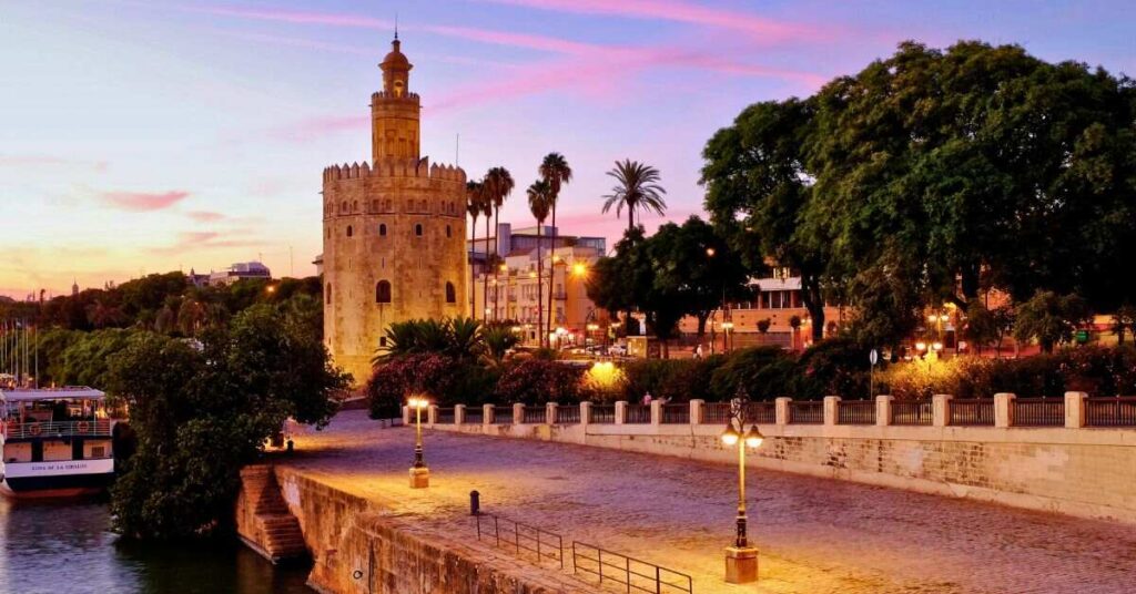 The torre del oro at sunset. Late evening river walks are one of the best things to do in Seville in July.
